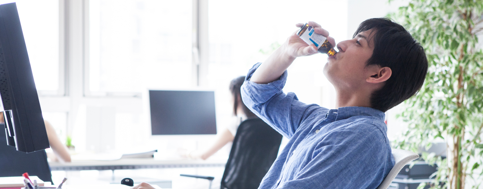 栄養ドリンクを服用して疲労回復を期待する男性